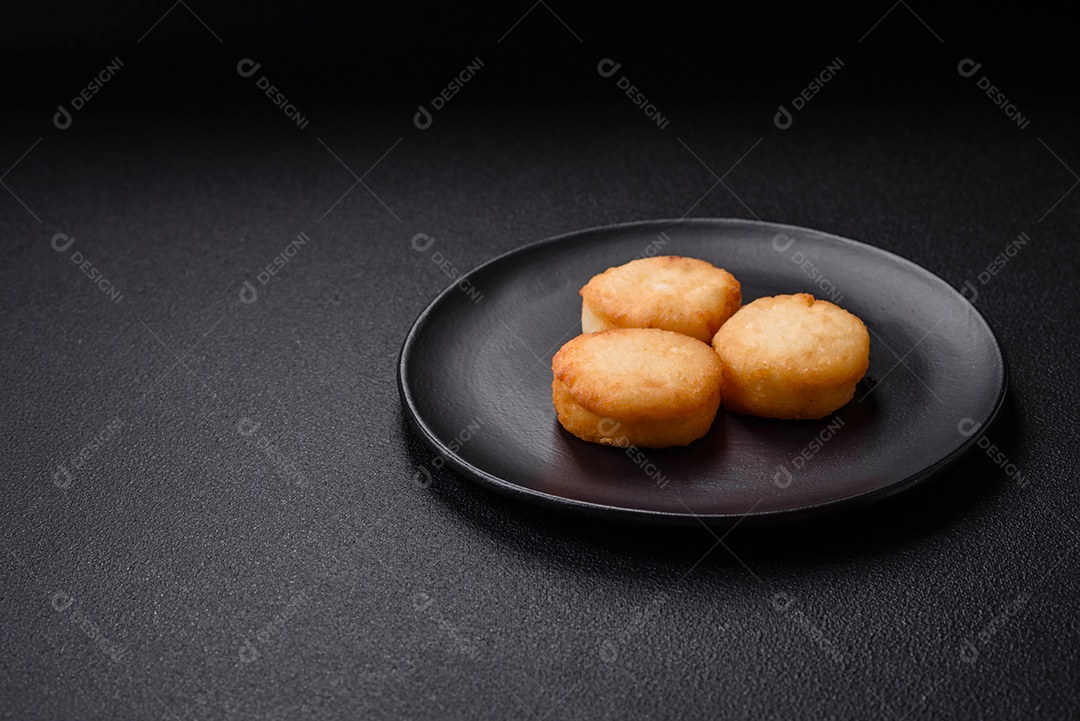Deliciosas panquecas de queijo doce fresco com passas e canela num prato de cerâmica