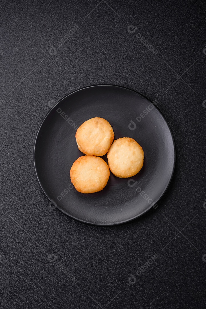 Deliciosas panquecas de queijo doce fresco com passas e canela num prato de cerâmica