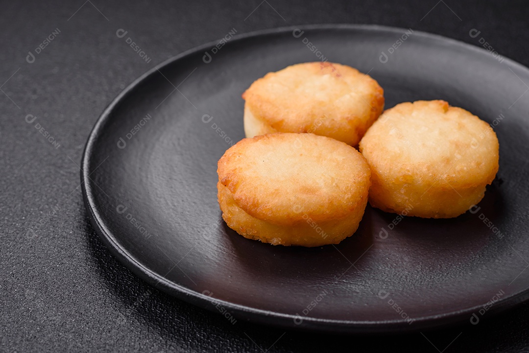 Deliciosas panquecas de queijo doce fresco com passas e canela num prato de cerâmica