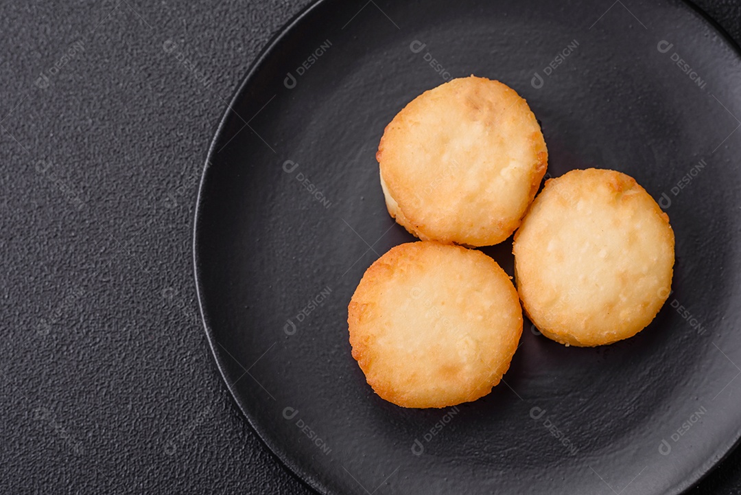 Deliciosas panquecas de queijo doce fresco com passas e canela num prato de cerâmica