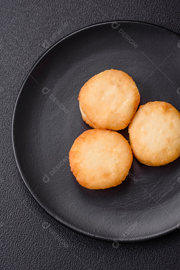 Deliciosas panquecas de queijo doce fresco com passas e canela num prato de cerâmica