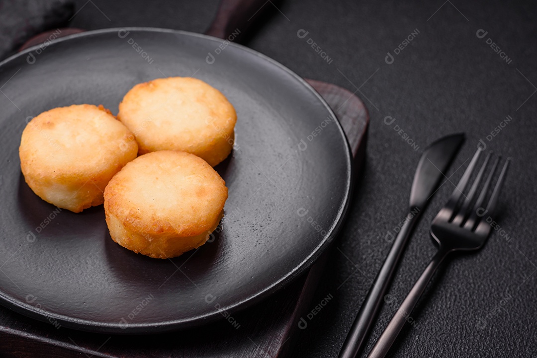 Deliciosas panquecas de queijo doce fresco com passas e canela num prato de cerâmica