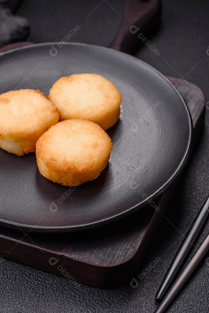 Deliciosas panquecas de queijo doce fresco com passas e canela num prato de cerâmica