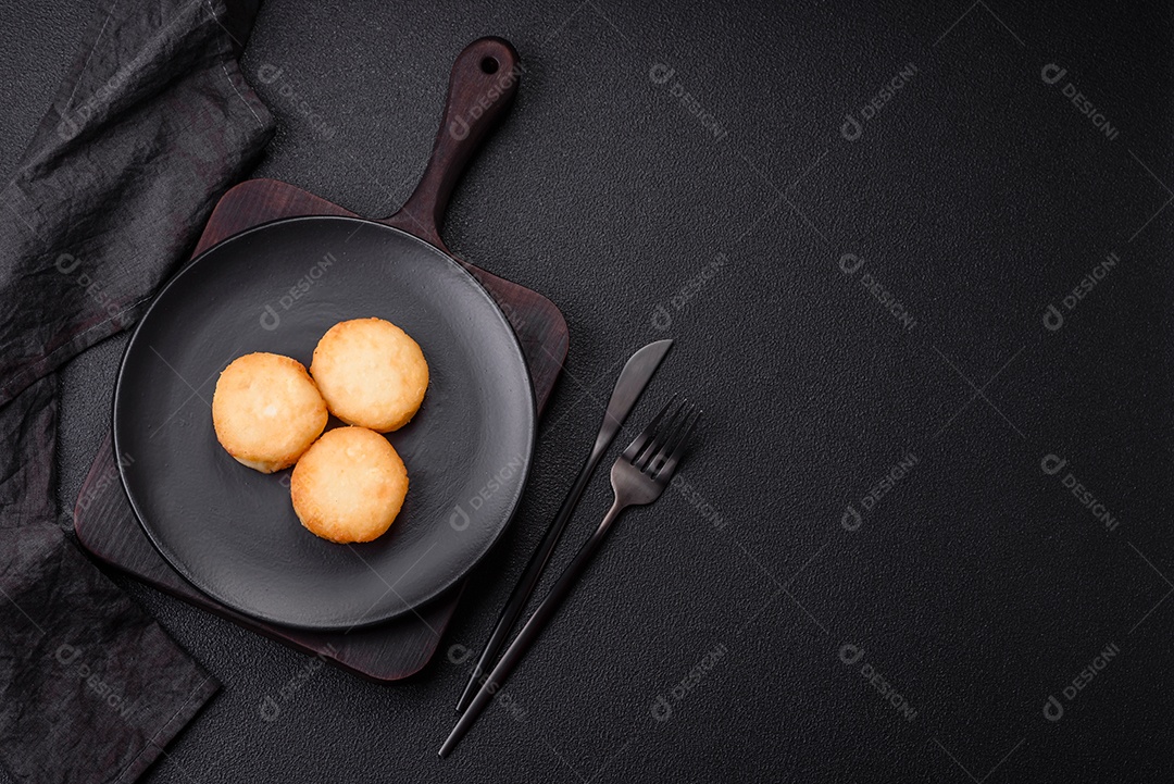 Deliciosas panquecas de queijo doce fresco com passas e canela num prato de cerâmica