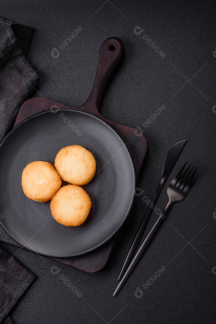 Deliciosas panquecas de queijo doce fresco com passas e canela num prato de cerâmica