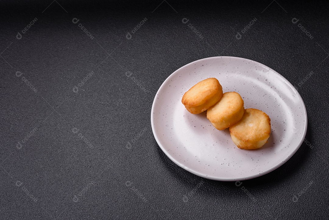 Deliciosas panquecas de queijo doce fresco com passas e canela num prato de cerâmica