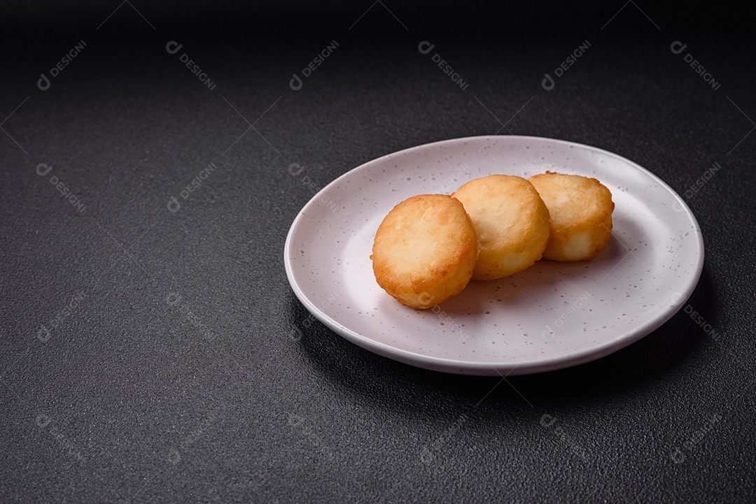 Deliciosas panquecas de queijo doce fresco com passas e canela num prato de cerâmica