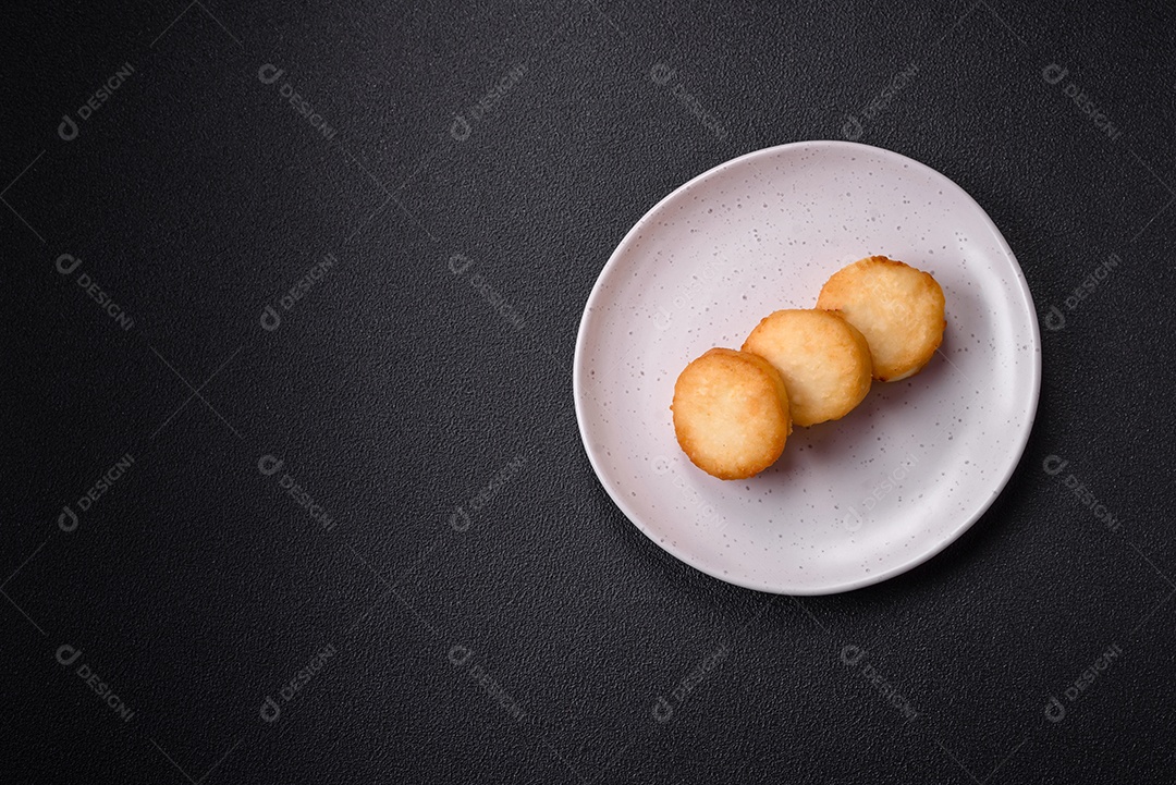 Deliciosas panquecas de queijo doce fresco com passas e canela num prato de cerâmica