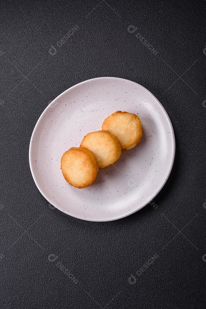Deliciosas panquecas de queijo doce fresco com passas e canela num prato de cerâmica