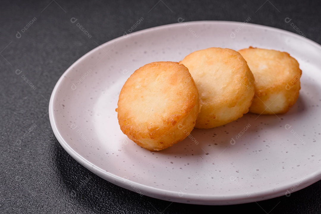 Deliciosas panquecas de queijo doce fresco com passas e canela num prato de cerâmica