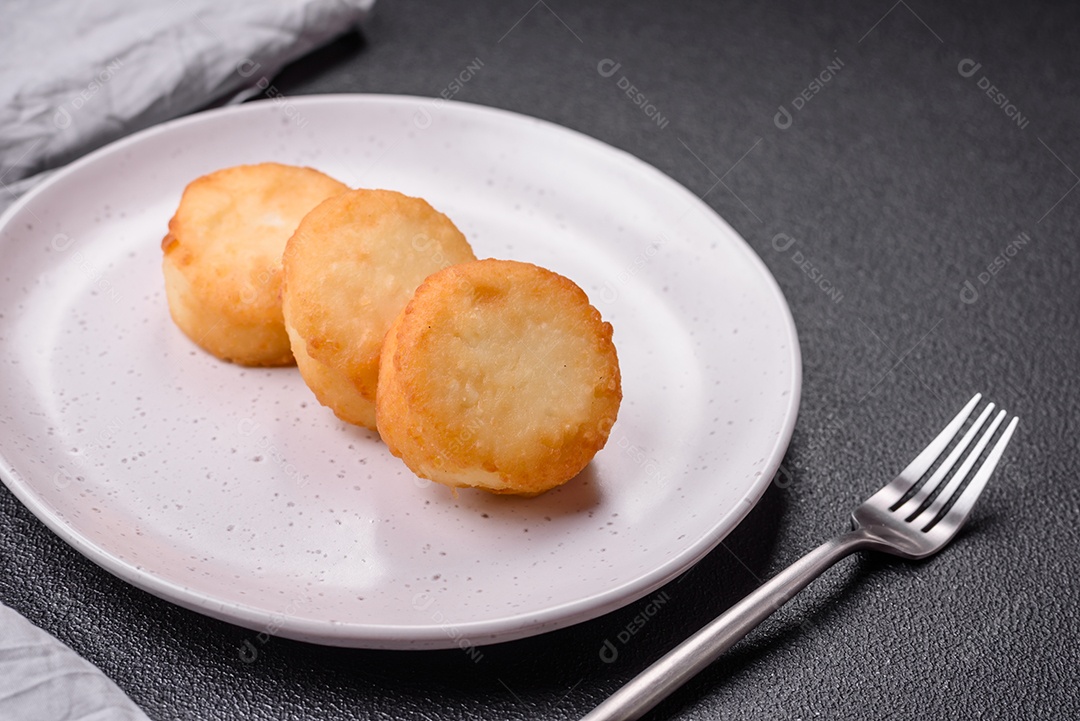 Deliciosas panquecas de queijo doce fresco com passas e canela num prato de cerâmica