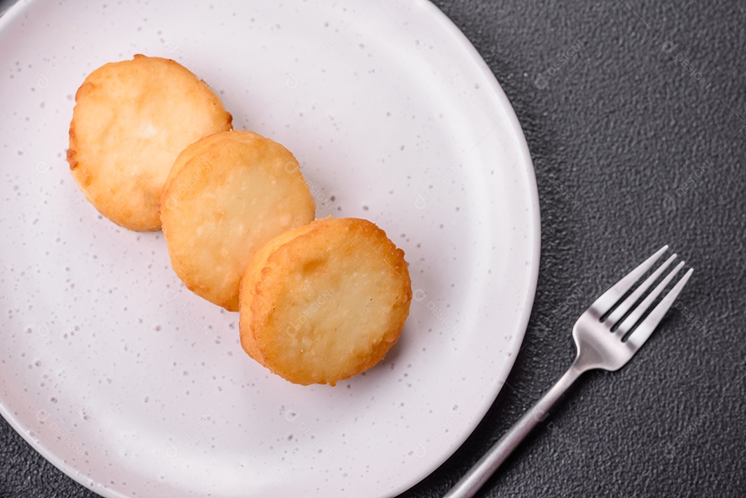 Deliciosas panquecas de queijo doce fresco com passas e canela num prato de cerâmica