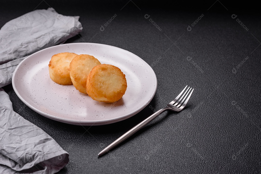 Deliciosas panquecas de queijo doce fresco com passas e canela num prato de cerâmica