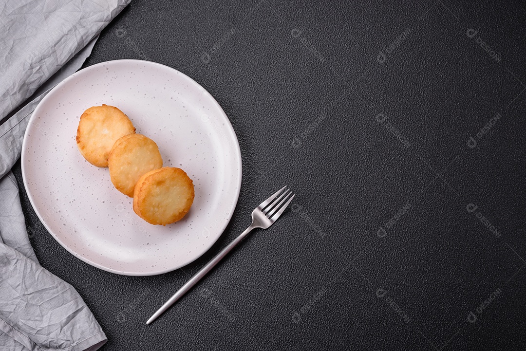 Deliciosas panquecas de queijo doce fresco com passas e canela num prato de cerâmica