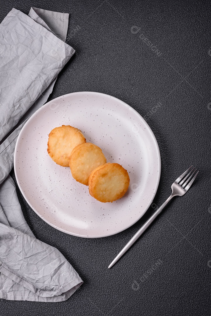 Deliciosas panquecas de queijo doce fresco com passas e canela num prato de cerâmica