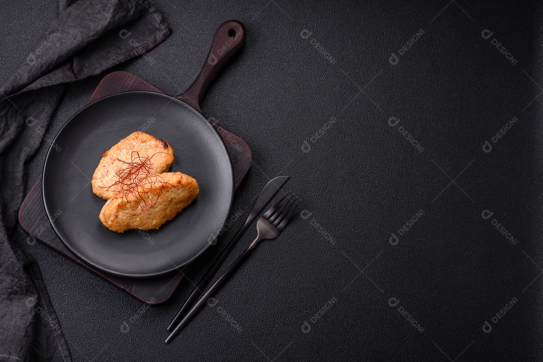 Deliciosas costeletas ou almôndegas fritas com sal, especiarias e ervas sobre um fundo escuro de concreto