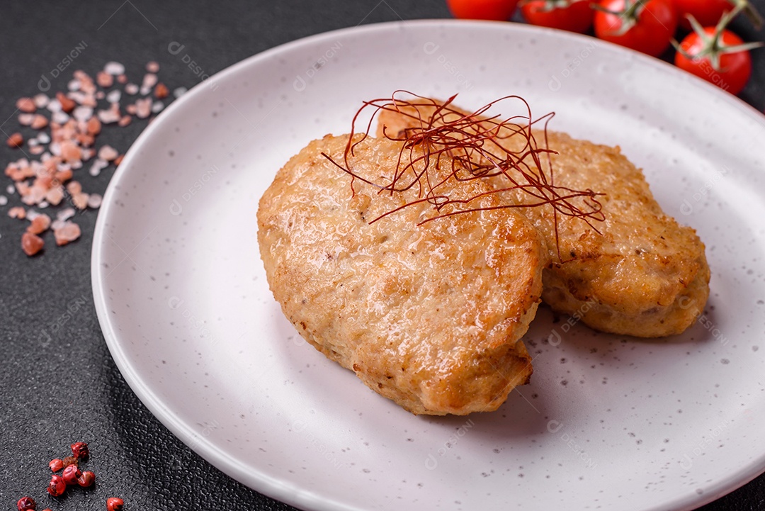 Deliciosas costeletas ou almôndegas fritas com sal, especiarias e ervas sobre um fundo escuro de concreto