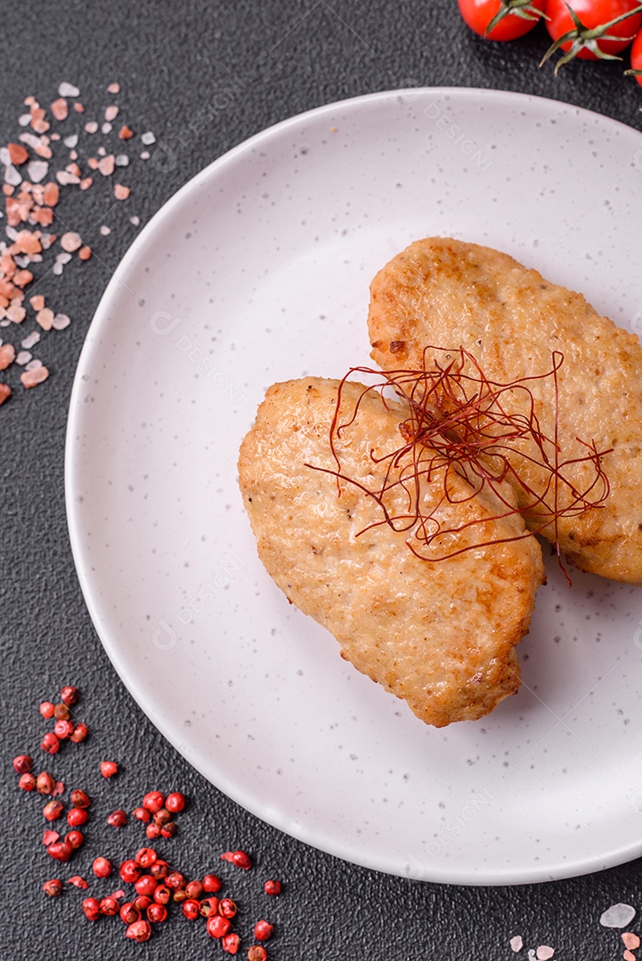 Deliciosas costeletas ou almôndegas fritas com sal, especiarias e ervas sobre um fundo escuro de concreto