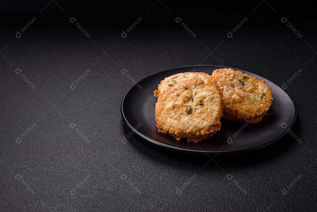Deliciosas costeletas ou almôndegas fritas com sal, especiarias e ervas sobre um fundo escuro de concreto