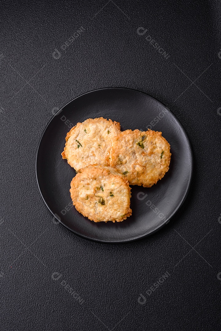 Deliciosas costeletas ou almôndegas fritas com sal, especiarias e ervas sobre um fundo escuro de concreto