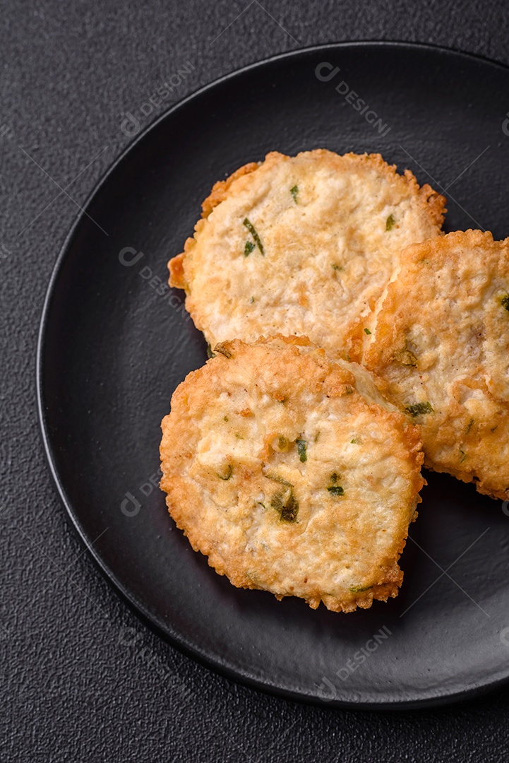 Deliciosas costeletas de peixe picado frito ou almôndegas com sal, especiarias e ervas sobre um fundo escuro de concreto