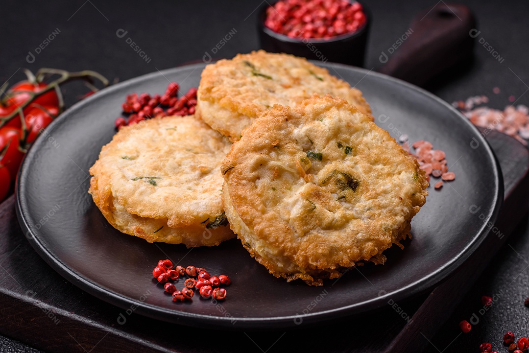 Deliciosas costeletas ou almôndegas fritas com sal, especiarias e ervas sobre um fundo escuro de concreto