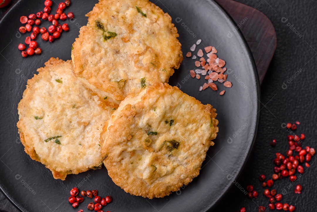 Deliciosas costeletas ou almôndegas fritas com sal, especiarias e ervas sobre um fundo escuro de concreto