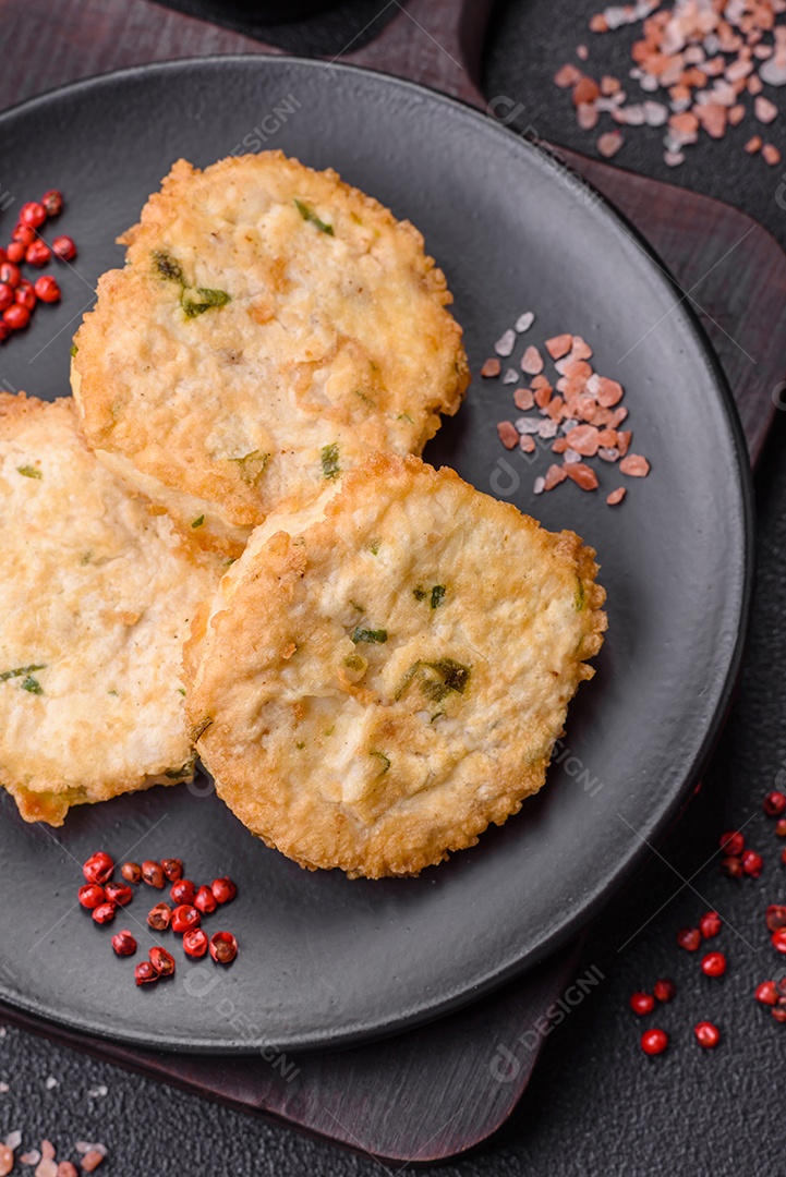 Deliciosas costeletas ou almôndegas fritas com sal, especiarias e ervas sobre um fundo escuro de concreto