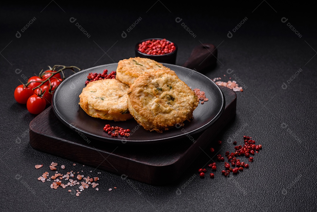 Deliciosas costeletas ou almôndegas fritas com sal, especiarias e ervas sobre um fundo escuro de concreto