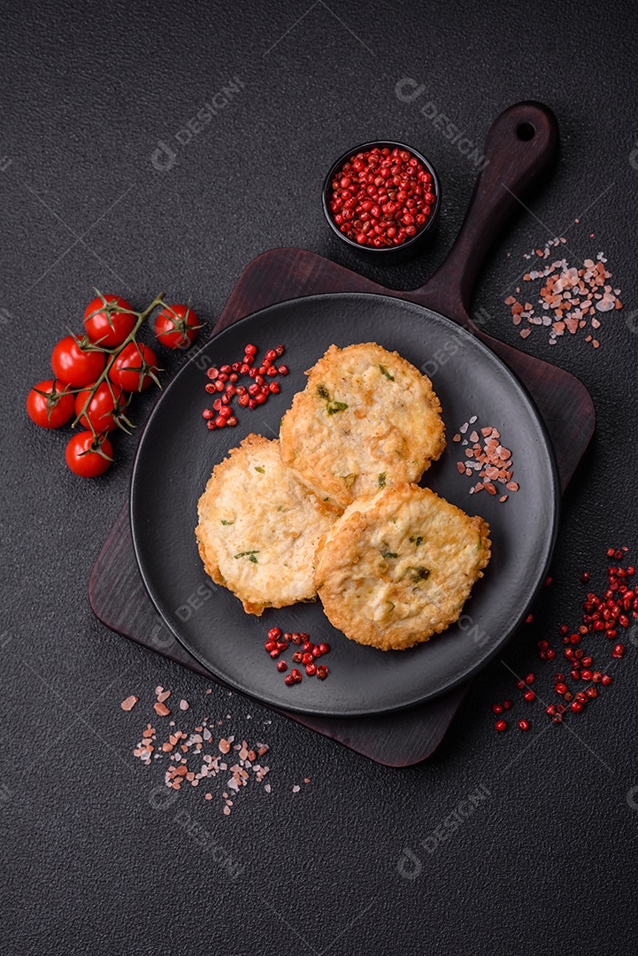 Deliciosas costeletas ou almôndegas fritas com sal, especiarias e ervas sobre um fundo escuro de concreto