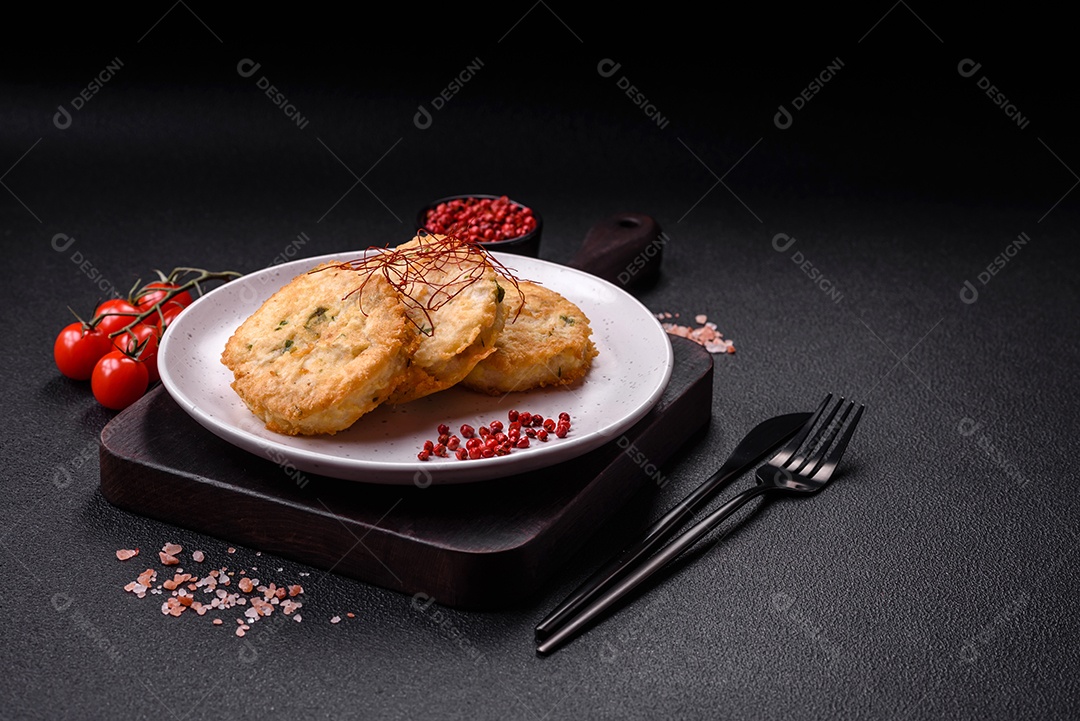 Deliciosas costeletas ou almôndegas fritas com sal, especiarias e ervas sobre um fundo escuro de concreto