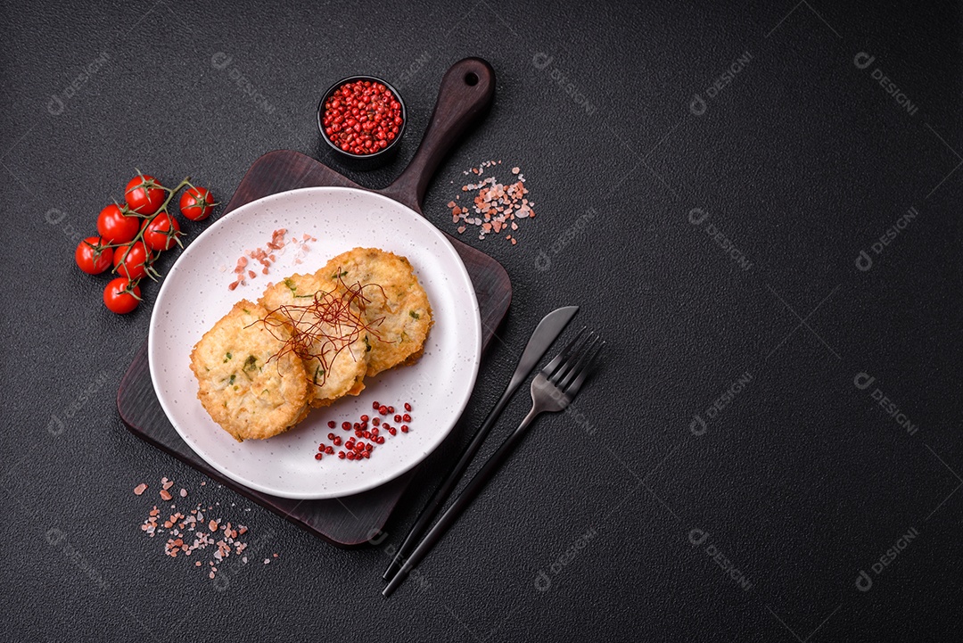 Deliciosas costeletas ou almôndegas fritas com sal, especiarias e ervas sobre um fundo escuro de concreto