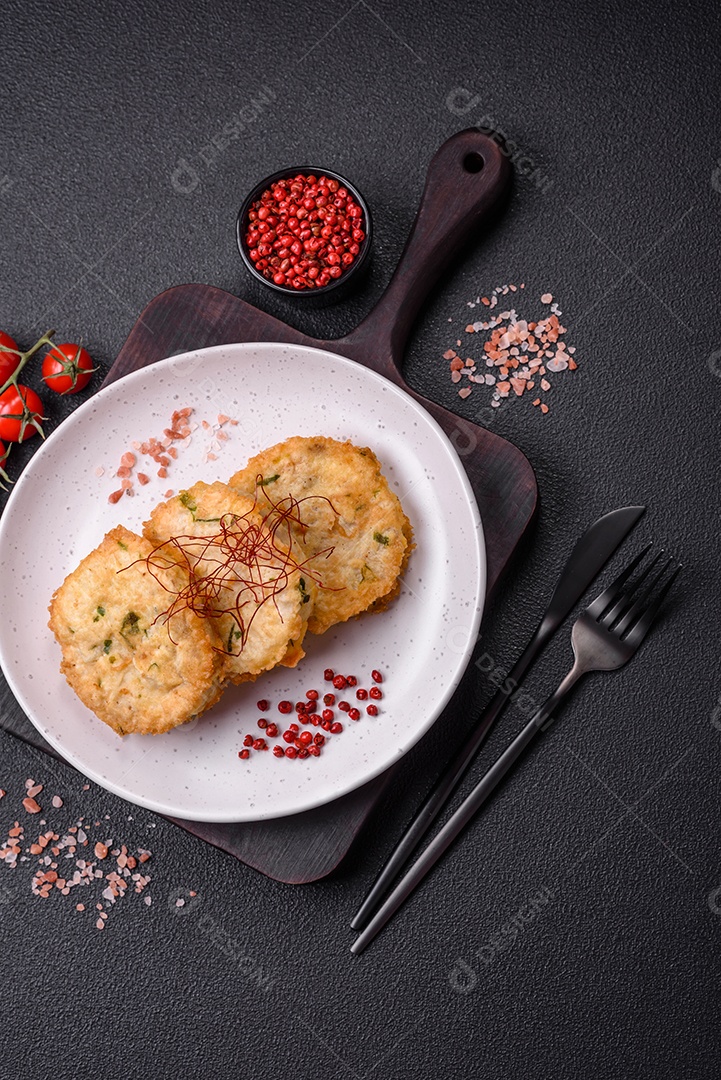 Deliciosas costeletas ou almôndegas fritas com sal, especiarias e ervas sobre um fundo escuro de concreto