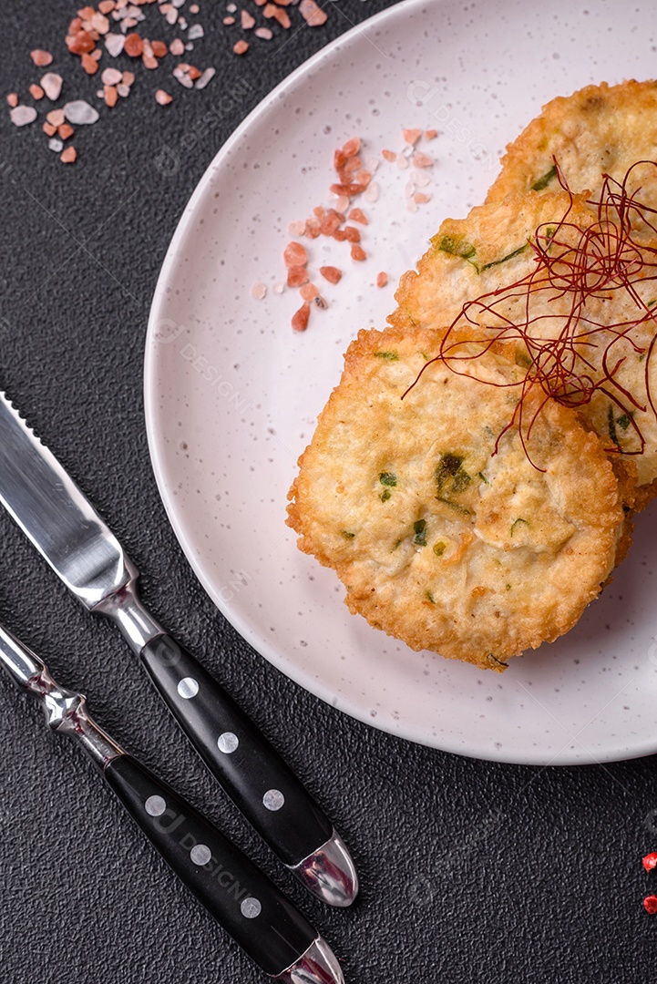 Deliciosas costeletas ou almôndegas fritas com sal, especiarias e ervas sobre um fundo escuro de concreto