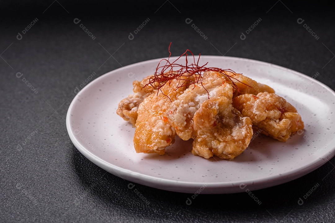 Deliciosos suculentos pedaços de frango grelhado em molho agridoce com sal e especiarias num prato cerâmico