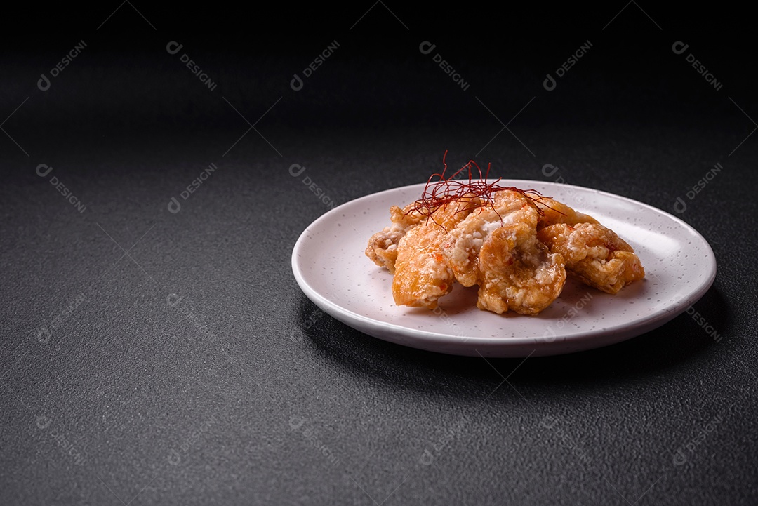 Deliciosos suculentos pedaços de frango grelhado em molho agridoce com sal e especiarias num prato cerâmico