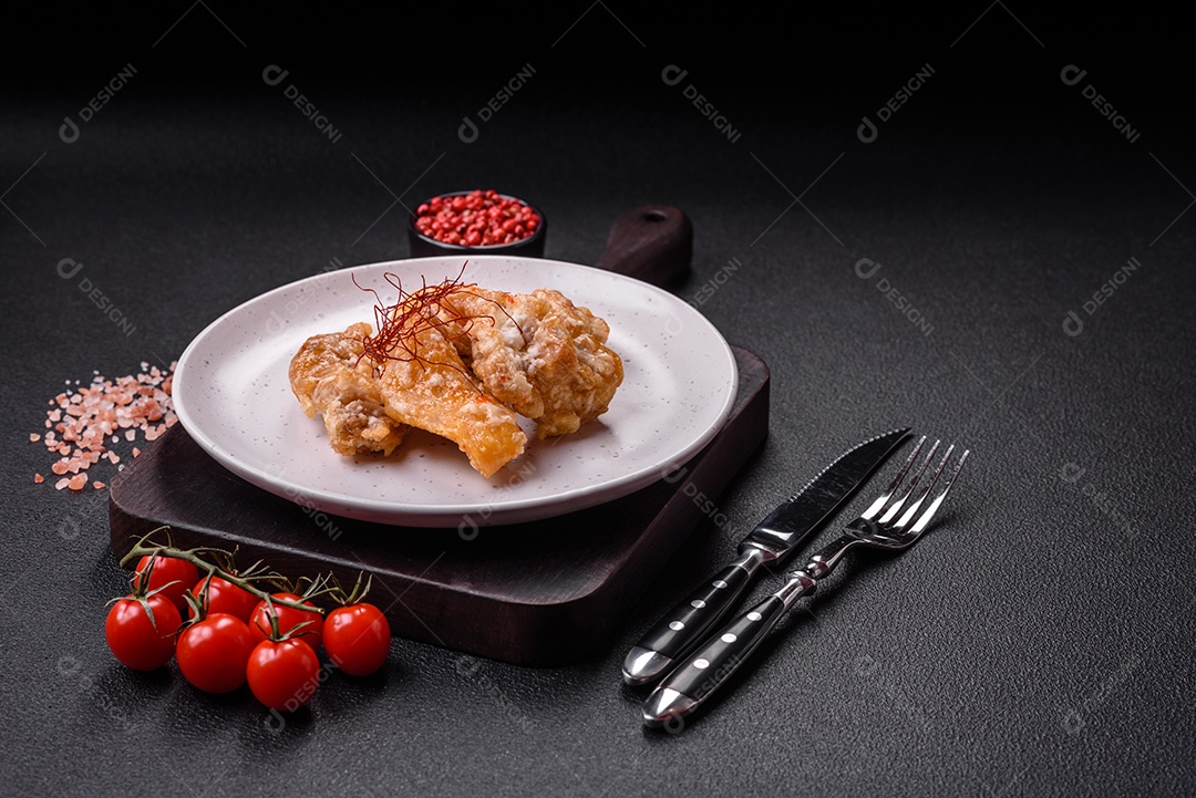 Deliciosos suculentos pedaços de frango grelhado em molho agridoce com sal e especiarias num prato cerâmico