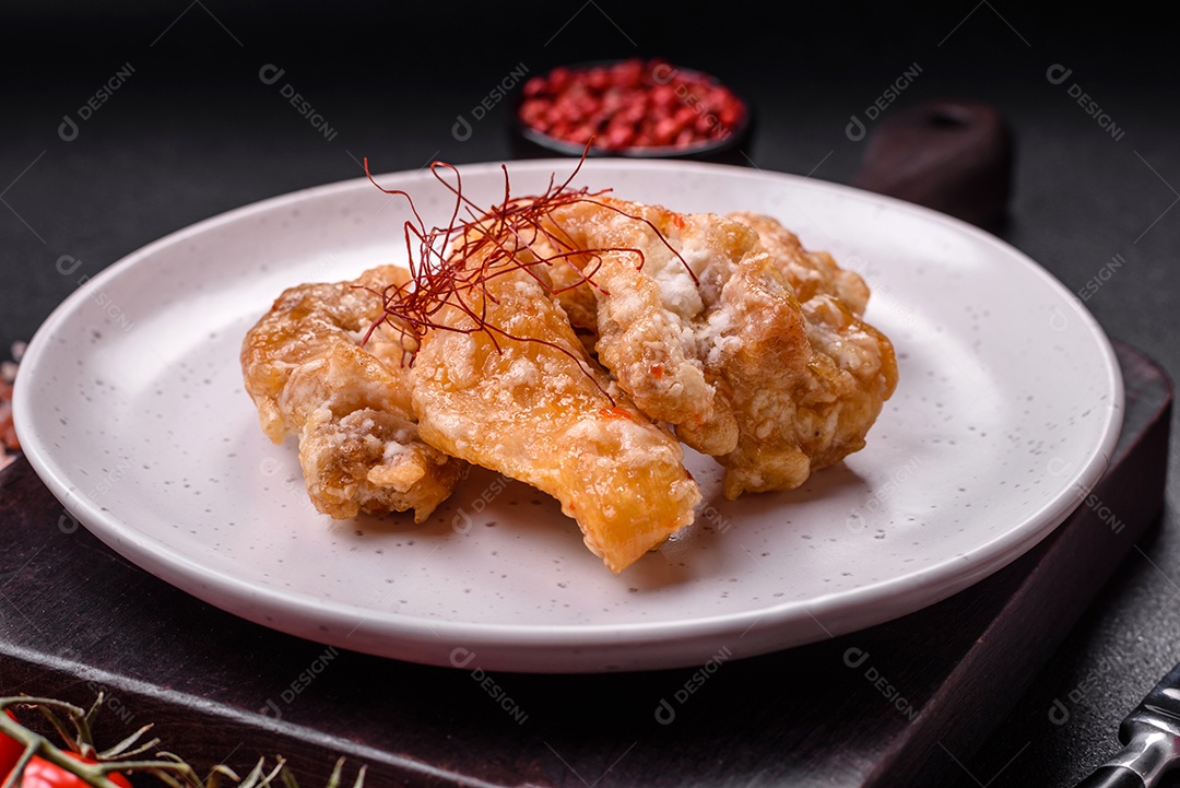 Deliciosos suculentos pedaços de frango grelhado em molho agridoce com sal e especiarias num prato cerâmico