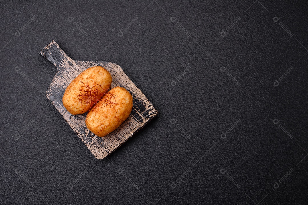 Deliciosa costeleta de batata assada recheada com frango e legumes, especiarias e sal sobre um fundo escuro de concreto