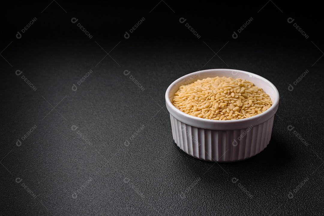 Massa orzo crua integral como ingrediente de um prato delicioso. Prato da cozinha mediterrânea