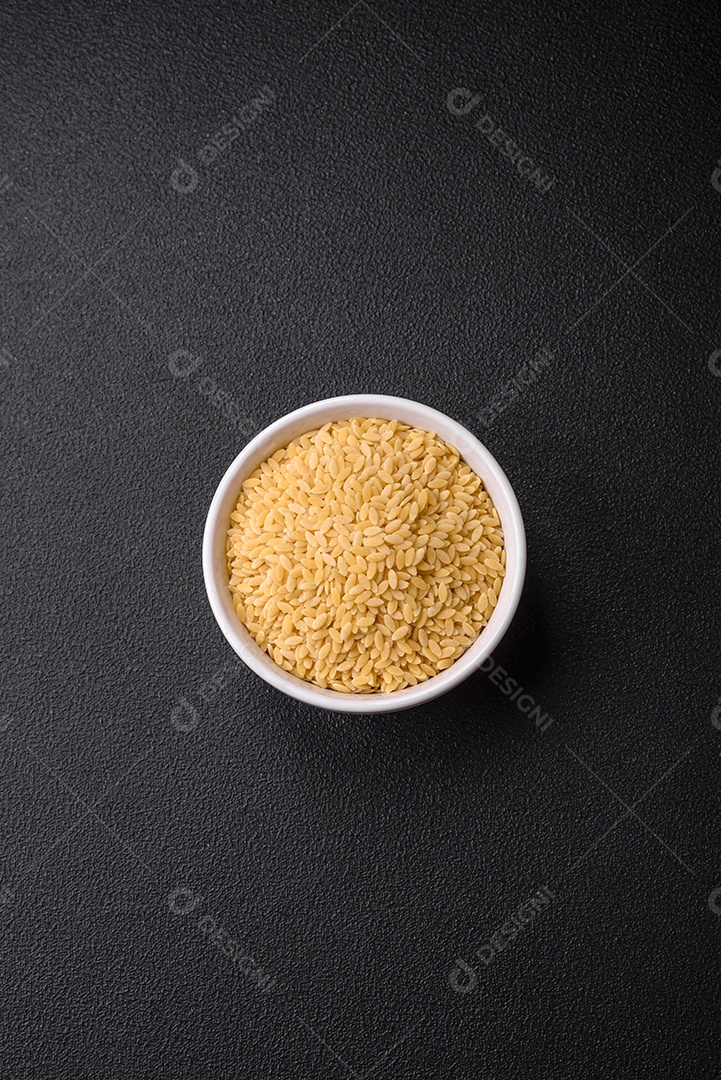 Massa orzo crua integral como ingrediente de um prato delicioso. Prato da cozinha mediterrânea