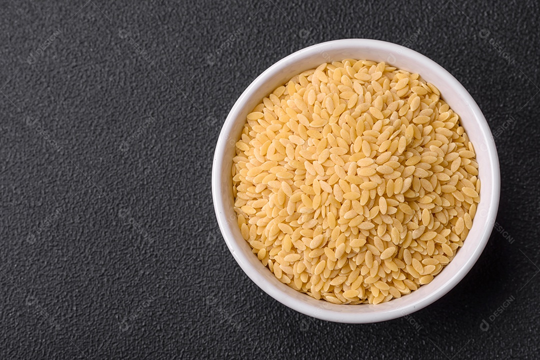 Massa orzo crua integral como ingrediente de um prato delicioso. Prato da cozinha mediterrânea