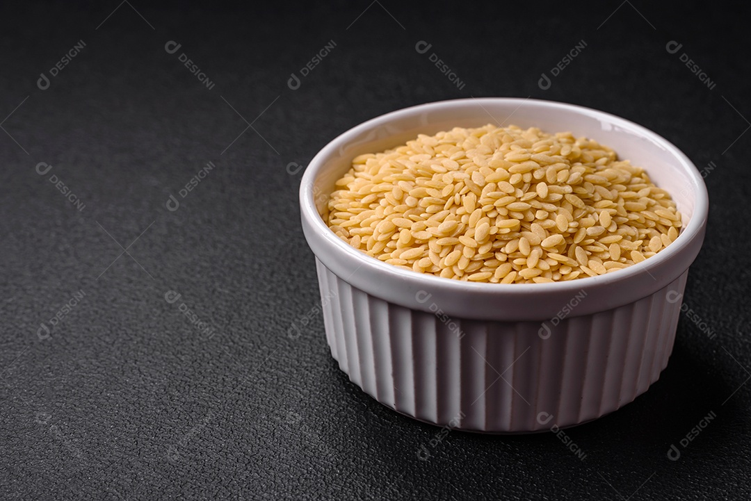 Massa orzo crua integral como ingrediente de um prato delicioso. Prato da cozinha mediterrânea