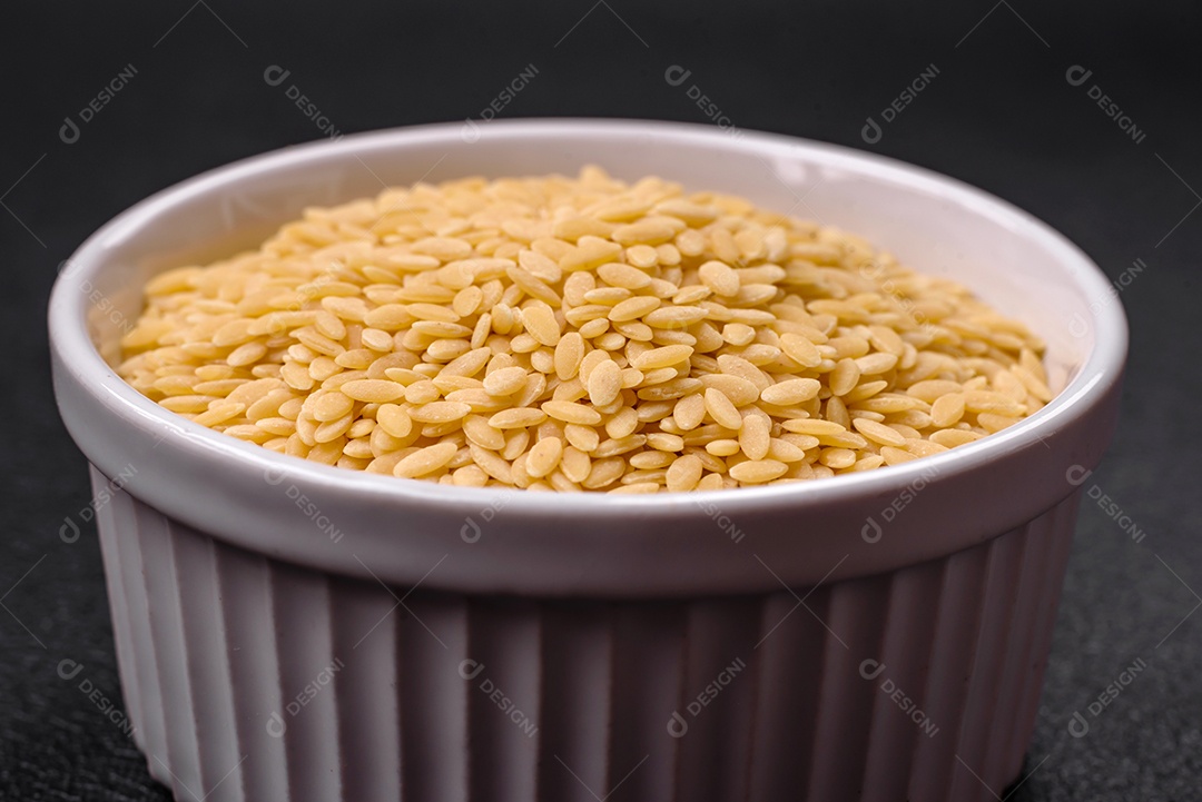 Massa orzo crua integral como ingrediente de um prato delicioso. Prato da cozinha mediterrânea