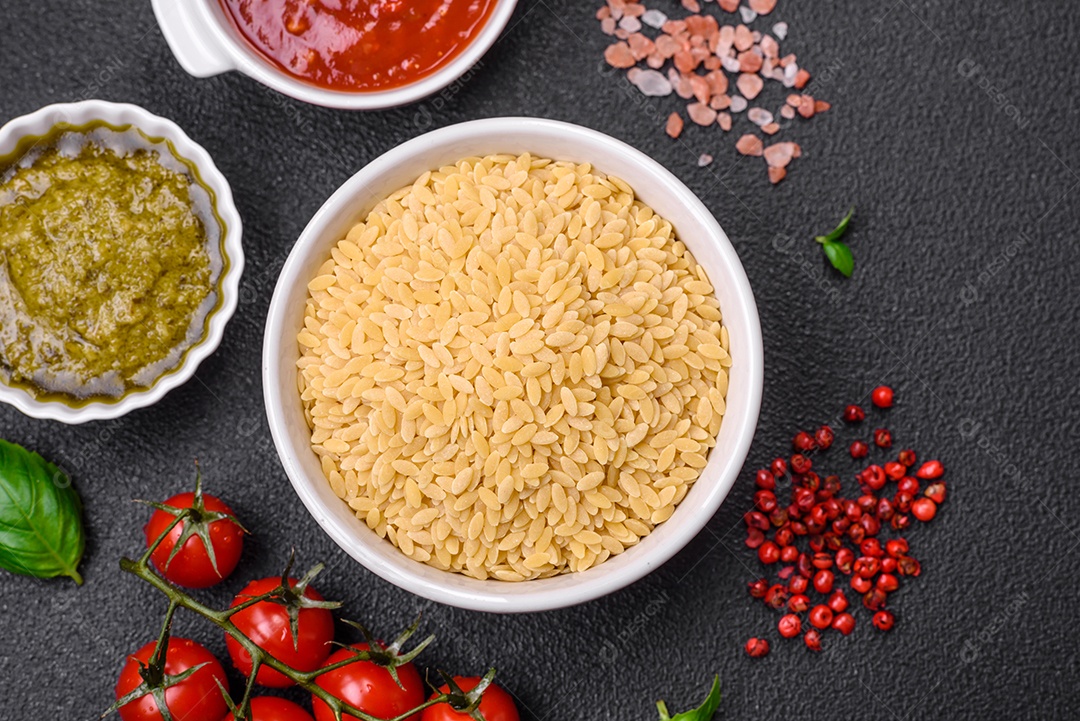 Massa orzo crua integral como ingrediente de um prato delicioso. Prato da cozinha mediterrânea