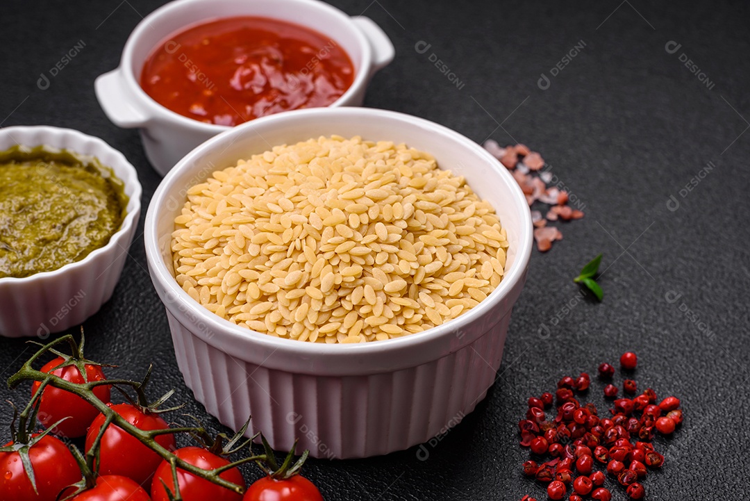 Massa orzo crua integral como ingrediente de um prato delicioso. Prato da cozinha mediterrânea