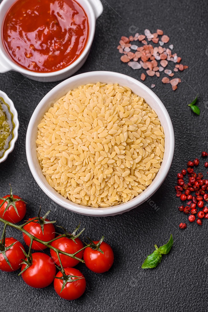 Massa orzo crua integral como ingrediente de um prato delicioso. Prato da cozinha mediterrânea