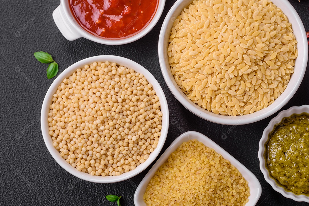 Massa orzo crua integral como ingrediente de um prato delicioso. Prato da cozinha mediterrânea