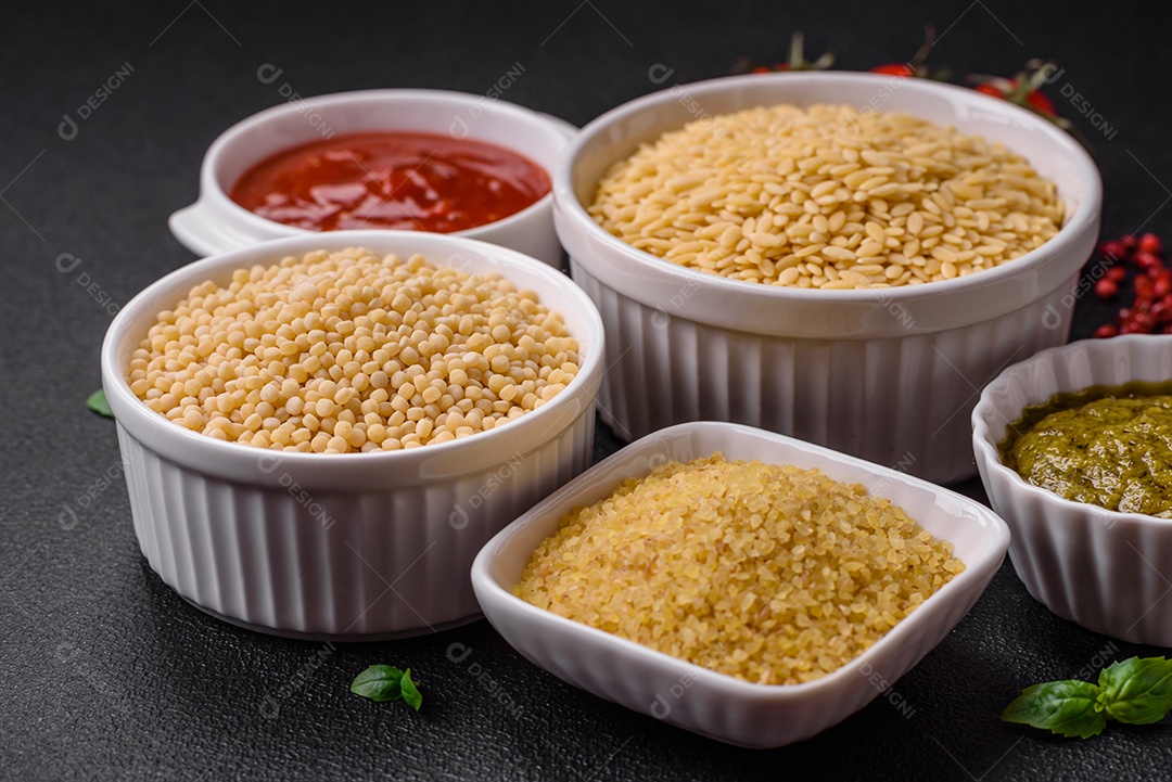 Massa orzo crua integral como ingrediente de um prato delicioso. Prato da cozinha mediterrânea