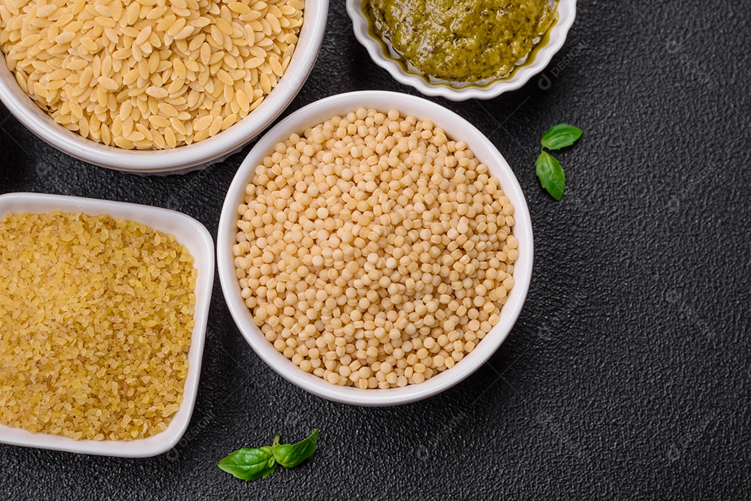 Massa orzo crua integral como ingrediente de um prato delicioso. Prato da cozinha mediterrânea